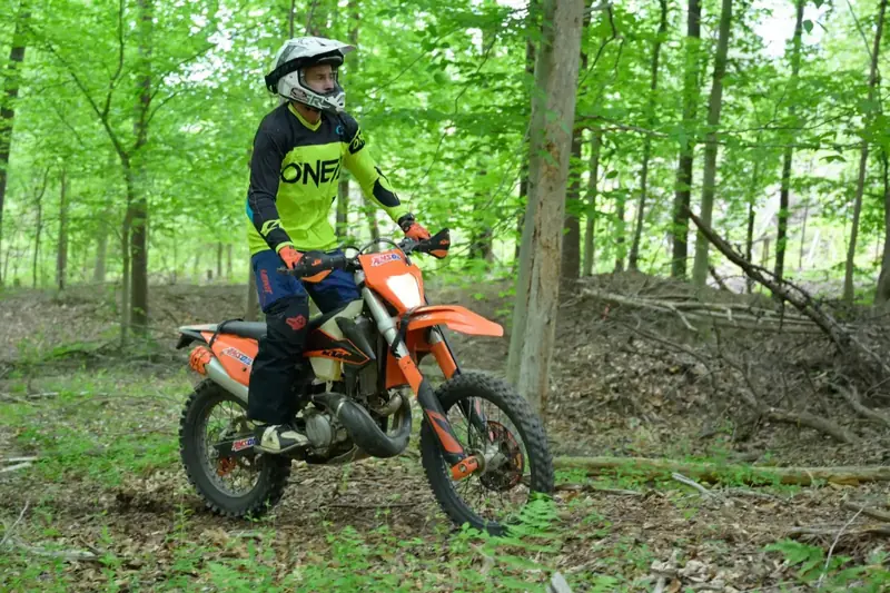 Dirt bike rider on an orange bike in the woods at Throttle Therapy Lake Anna